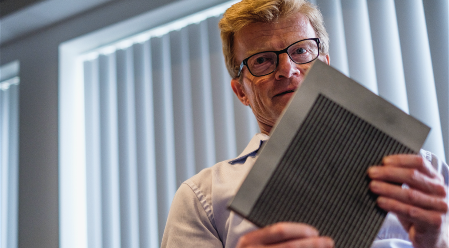 Mand står og holder metalelement fra radar